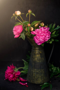 Peonies in an iron vase against a beautiful sunset
