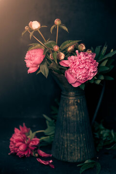 Peonies in an iron vase against a beautiful sunset