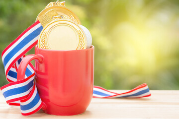 gold medal and red cup coffee on wood in morning, soft background, Winer concept