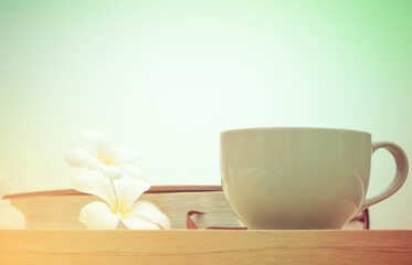 coffee cup book and white flower on wooden table,  in morning