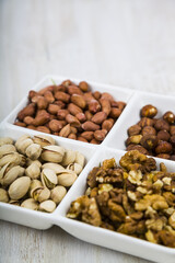 Nuts in a plate on a  wooden table.