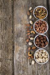 Nuts in a plate on a  wooden table.