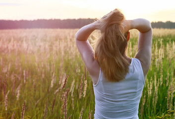 Beautiful blondie lady in field at sunset, feels happy. Instagram