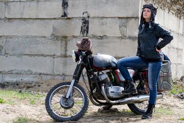 Fototapeta na wymiar A post apocalyptic woman near motorcycle near the destroyed building