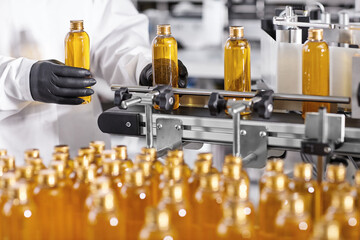 Plastic bottles with yellow liquid substance of shampoo, shower gel or soap standing in rows on...