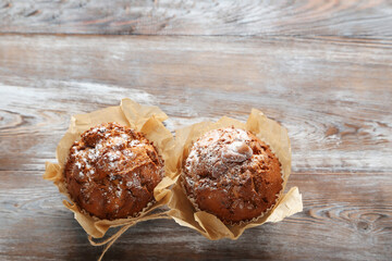 Tasty muffins on grey wooden table