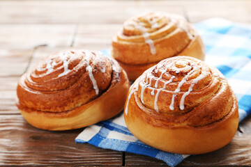 Cinnamon buns with napkin on wooden table