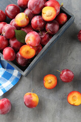Naklejka na ściany i meble Fresh plums on a grey wooden table