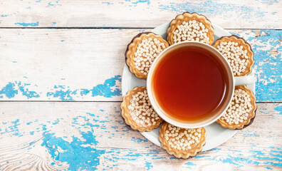 Cookies and cup with tea on the table. Top view.