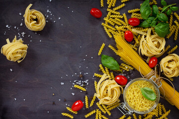 Ingredients for the preparation of Italian pasta - spaghetti, fusilli, fettuccine, basil, cherry...