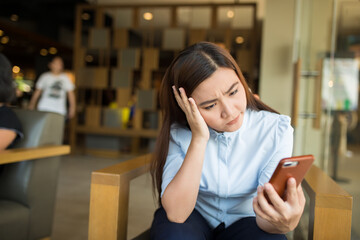 Woman using smartphone in cafe and she feel worried