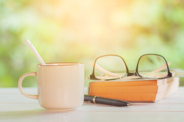 Morning coffee with glasses and book on white table
