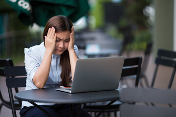 Woman  using laptop at cafe she feel worried