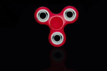Fidget Spinner in black isolated background for stress release during work
