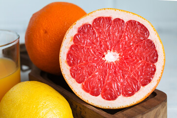 Fototapeta na wymiar Grapefruit half among citrus fruits. Closeup.