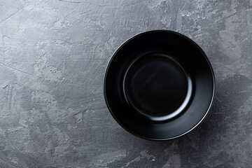 Empty black soup plate on dark grey background, top view © Sea Wave