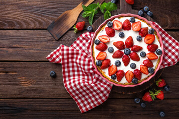 Delicious strawberry pie with fresh blueberry and whipped cream on wooden rustic table, cheesecake,...