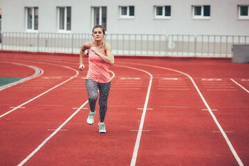 Fototapeta premium Track runner athlete woman warming up before running at a stadium