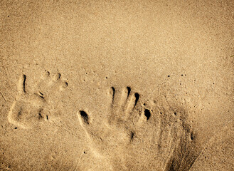 Handabdrücke im Sand am Strand