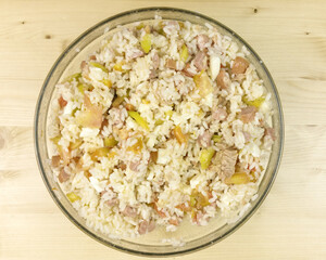 Simple rice salad in a transparent bowl on wooden background - top view