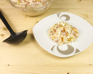 Simple rice salad in a transparent bowl on wooden background - top view