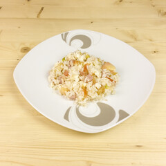 Simple rice salad in a transparent bowl on wooden background - top view
