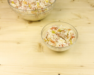 Simple rice salad in a transparent bowl on wooden background - top view