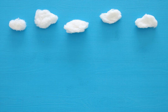 image of cotton shaped clouds over blue wooden background