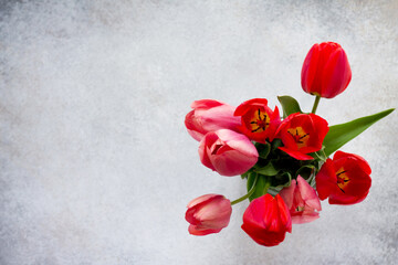 Background to the mother's day or birthday. Beautiful fresh pink and red tulips flowers in a vase. Top view. Copy space.