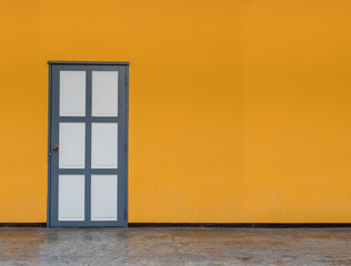 Closed white  wooden door on yellow wall background with space for text