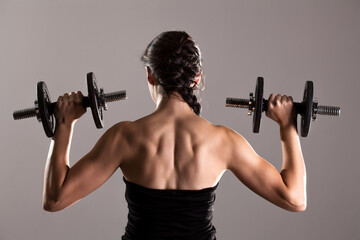 Fototapeta na wymiar girl in sexy black dress lifting weights