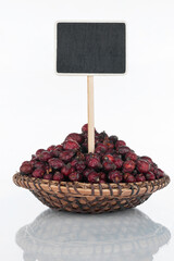 Plate with a bunch of dried rosehip and its reflection and price tag, pointer.