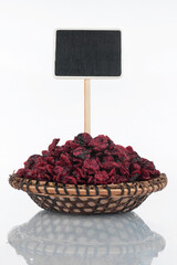 Plate with a bunch of dried cranberry and its reflection and price tag, pointer.