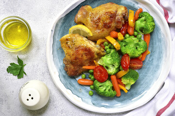 Grilled chicken thigh garnished with vegetables.Top view.