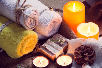 SPA consist from towels, candles, soap, flowers, and fir cone 