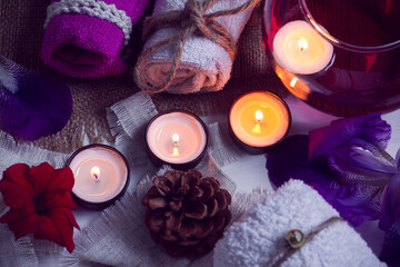 Obraz na płótnie Canvas SPA consist from towels, candles, flowers, cone and aromatherapy water in a glass bowl