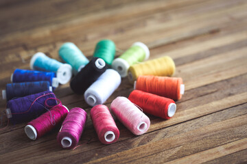 bobines de fils arc-en-ciel sur fond bois 