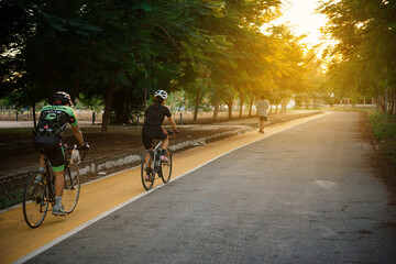 Naklejka premium Portrait of a handsome man riding a bike with his on the park with sunset light