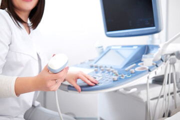 Crop of incognito professional nurse in white uniform holding at hands and using ultrasound...