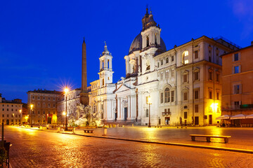 Fototapeta na wymiar Fountain of the Four Rivers with an Egyptian obelisk and Sant Agnese Church on the famous Piazza Navona Square at night, Rome, Italy.