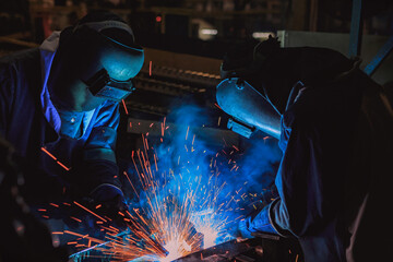 Team welder are welding in car factory
