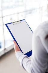 Hands of business woman that  hold paper and writing something on it