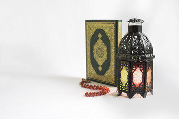 Quran, Lantern and rosary on white background