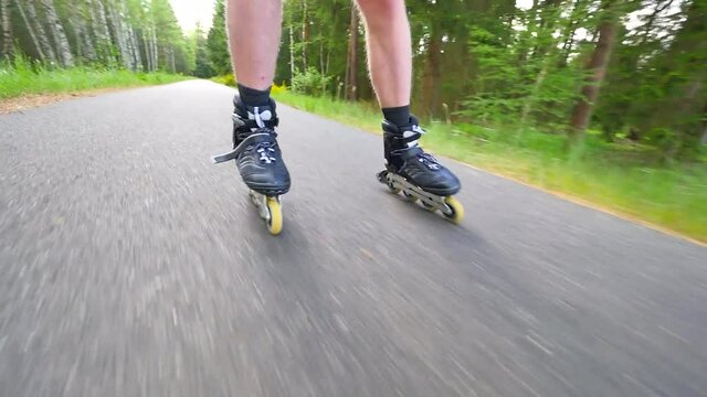 Backwards inline skating and braking on the asphalt. Close up view to move man legs and slow down. Easy backwards ride and slowing down.