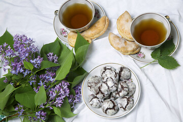 Cup of Tea  with homemade chocolate breakfast  cookies  and spring flowers. Homemade biscuit. Sweet dessert pastry.