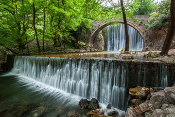 Fototapeta na wymiar Wunderschöne alte Steinbrücke zwischen zwei Wasserfällen in Paleokaria Griechenland