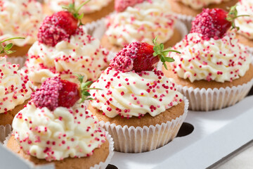 Vanilla cupcakes decorated fresh strawberries in delivery box