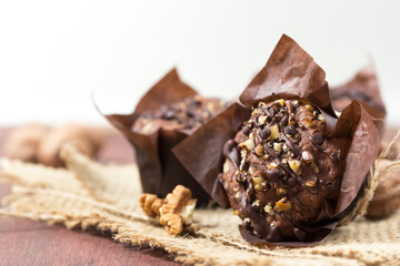Chocolate muffins with walnuts, rustic background, selective focus