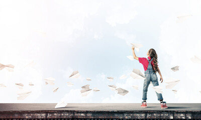 Concept of careless happy childhood with girl dreaming to become