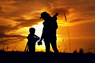 Silhouettes of mother photographer and little son